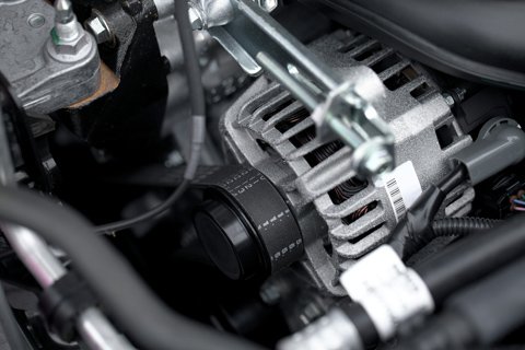 Mechanic servicing belts and hoses